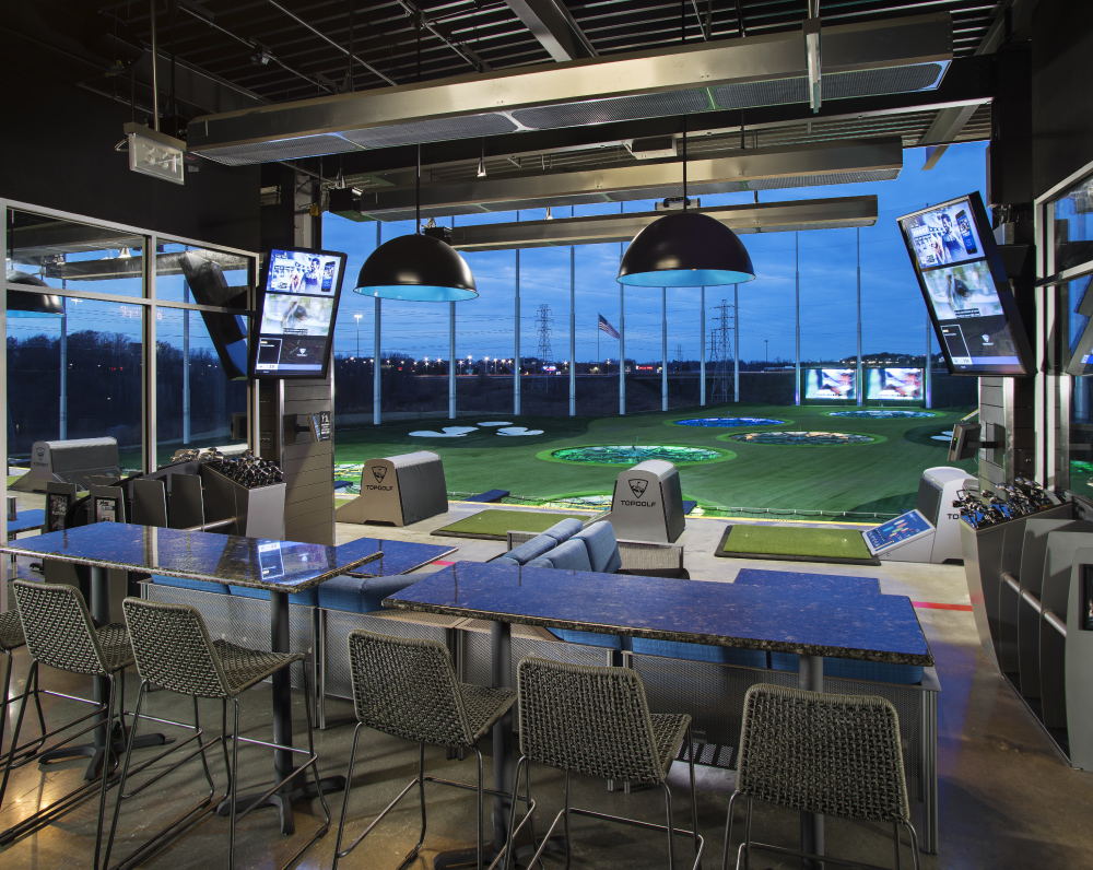 arco-national-construction-company-topgolf-auburn-hills-michigan-gallery-1 a hitting bay and tables of the topgolf sports entertainment facility in auburn hills michigan